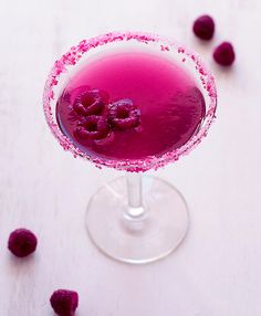 a purple drink with raspberries on the rim