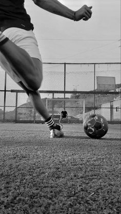 a man kicking a soccer ball on top of a field