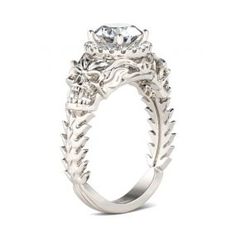 a white gold engagement ring with an intricate floral design on the band and center stone