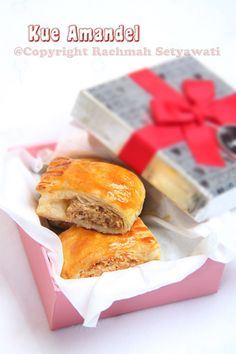 two pastries in a pink box with a red bow