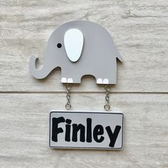 a sign with an elephant hanging from it's side that says finley on the front