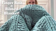 a woman wrapped in a blanket with the words finger knit a ribbed blanket