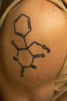 a tattoo on the back of a woman's shoulder that has chemical symbols drawn on it