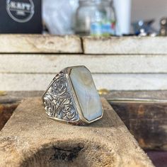 This handmade large men's ring features a striking design with a white mother of pearl inlay and intricately engraved motifs on the sides. Crafted with attention to detail, this unique piece showcases the beauty of natural materials and artisanal craftsmanship. The white mother of pearl adds a touch of elegance, while the engraved motifs bring a sense of depth and character to the ring. This statement accessory is perfect for those who appreciate bold and distinctive jewelry. Add a touch of soph Minimal Ring, Mother Of Pearl Inlay, Pearl Inlay, Large Man, Men's Ring, Signet Ring, The White, Mother Of Pearl, Favorite Jewelry