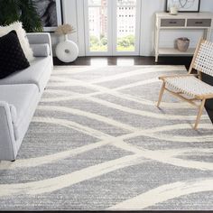 a living room filled with furniture and a white rug