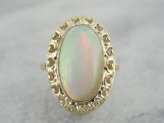 The frame work of this ring is a combination of yellow and green gold, a lovely Art Nouveau look! The open work allows plenty of light in to the center of the stone, allowing the bright orange and green to really shine through. The simple bezel around the stone protects it from wear, and still allows the opal to glow! Metal: 14K Yellow and Green Gold Stone: Ethiopian Opal weighing 5.95 ct Accents: none Time Period: Vintage Ring with New Stone Size of Ring: 7 Marks: 14K Green Goldstone, Frame Work, Colored Stone Rings, Orange And Green, Gold Stone, Filigree Ring, Yellow And Green, Art Deco Jewelry, Vintage Ring