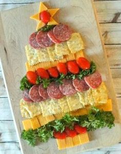 a christmas tree made out of crackers and cheese on a cutting board with tomatoes