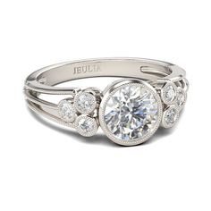 a white gold engagement ring with three round diamonds in the center and an intricate band