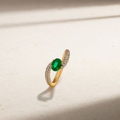 Resting brilliantly at the heart of this daring design is a striking oval shaped emerald that is secured by four claw prongs. Rows of sparkling diamonds embellish the shank as it gracefully spirals towards the center stone in what we consider a new-aged bypass ring. We love our Tempest Ring for the more audacious and in vogue lady. Metal: 18kt Gold Emerald Weight: 0.85 ct. Diamond Weight: 0.50 ct. Measurements: 9.0 mm length *Please note that the listed ct. weights are approximate and may be sub Oval Emerald Ring With Pave Diamond Setting, Oval Emerald Ring With Diamond Pave Setting, Oval Emerald Rings With Pave Setting, Timeless Oval Emerald Ring With Diamond Accents, Oval Emerald Ring With Pave Setting, Elegant Oval Solitaire Emerald Ring, Elegant Oval Emerald Ring With Diamond Accents, Oval Emerald Solitaire Ring With Diamond, Mark Henry