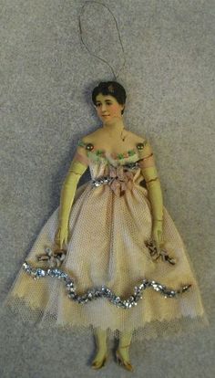 an ornament with a woman in a dress and gloves on it's head