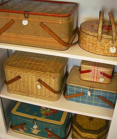 several suitcases and baskets on shelves in a closet