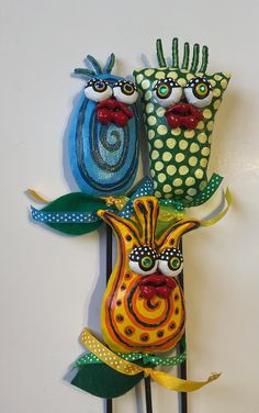 two colorful masks are on top of some black hair pins with green leaves and polka dots