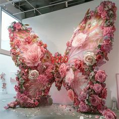 two pink butterflies made out of flowers and petals with the word love spelled on them