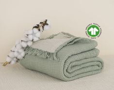 a pile of cotton sitting on top of a bed next to a green and white blanket