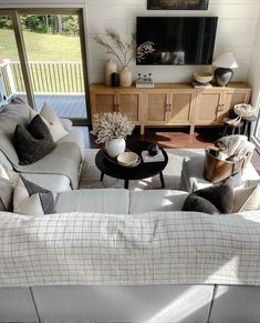 a living room filled with furniture and a flat screen tv on top of a wall