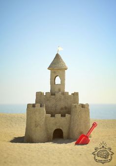 a sand castle on the beach with a shovel