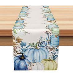 a table runner with blue and white pumpkins on it