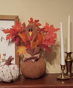 a table topped with a vase filled with leaves and a turkey