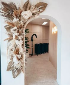 a hallway with a mirror and some plants on the wall next to an entrance way