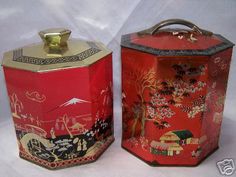 two red tins with designs on them sitting next to each other in front of a white background