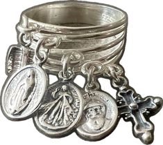 a silver ring with charms on it and a cross hanging from the middle of it