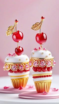 two small cupcakes with cherries on top