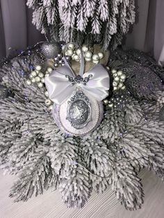 a christmas tree is decorated with silver and white ornaments