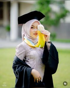 a woman wearing a graduation gown and holding a banana