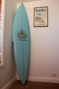 a blue surfboard leaning up against a wall