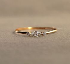 a gold ring with three diamonds on it