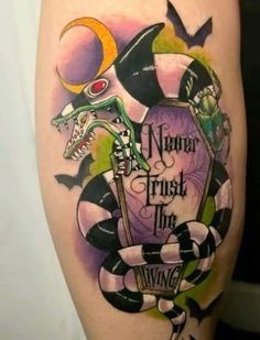 a tattoo on the leg of a person with a snake and witch hat in it