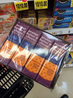 a person is holding up some crackers in a grocery store's display case