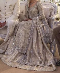 a man and woman in formal wear sitting on a couch