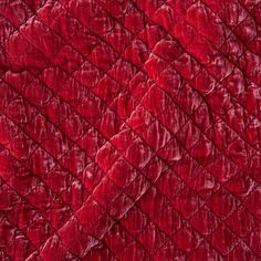 an up close shot of the texture of a red velvet fabric with wavy lines on it