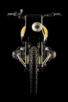 the front end of a motorcycle on a black background with gold trim and tire treads