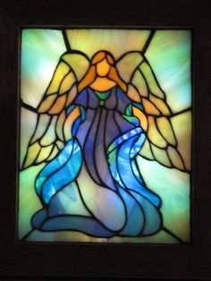 a stained glass window with an angel holding a blue stream in it's hand