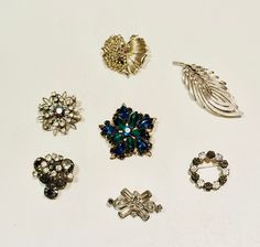 several different types of brooches on a white surface