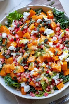 a salad with pomegranate, feta cheese and pumpkins