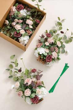 two boxes filled with flowers and greenery next to each other