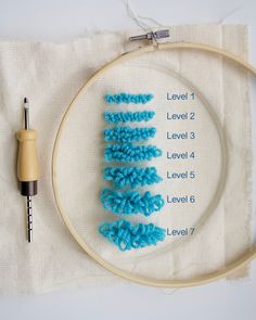 a close up of a cross stitch pattern on a piece of cloth next to a needle