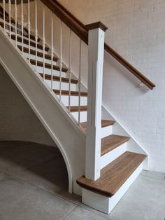 a white stair case with wooden handrails