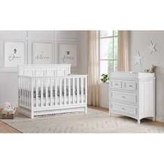 a white crib and dresser in a room