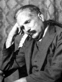 an old photo of a man in a suit and tie with his hand on his head