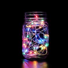 a jar filled with colorful lights on top of a table