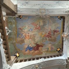 an ornate painting on the ceiling of a building with stairs leading up to it's second floor