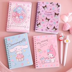 three notebooks are sitting on a pink plate next to an eraser and pen