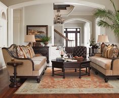 a living room filled with furniture and a chandelier hanging from the ceiling in front of a doorway