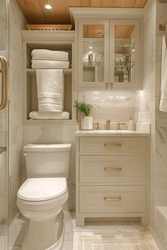 a white toilet sitting in a bathroom next to a sink under a wooden paneled ceiling