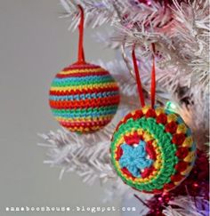 two crocheted ornaments hanging from a christmas tree