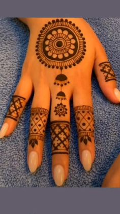 a woman's hand with henna tattoos on it